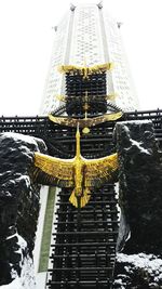 Close-up of golden gate against sky