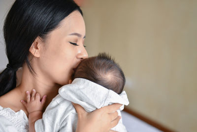 Close-up of mother with baby boy at home