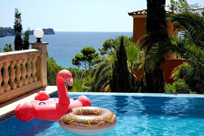 Swimming pool by sea against sky