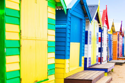 Multi colored umbrellas on beach huts against buildings