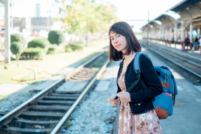 Woman standing on railroad station platform
