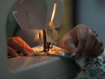 Close-up of woman stitching clothe on sewing machine