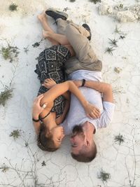 High angle view of friends lying on floor