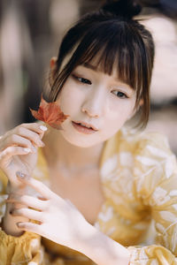 Close-up of young woman holding flower