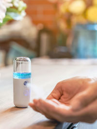 Close-up of hand holding glass on table