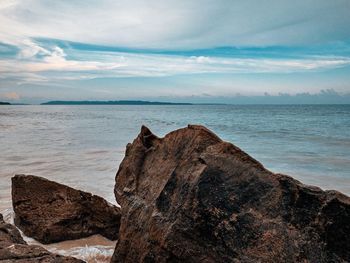 Scenic view of rocks on beach against sky