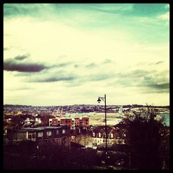 Buildings in town against cloudy sky