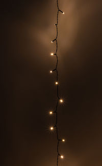 Low angle view of illuminated lights against sky at night