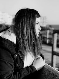 Young woman looking away by railing