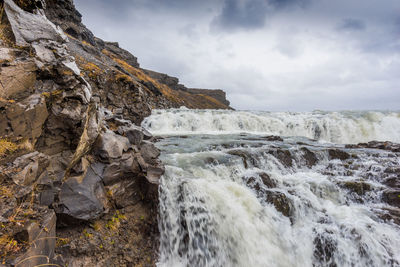 Scenic view of frozen waterfall against sky