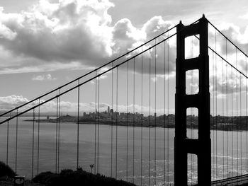 View of suspension bridge against cloudy sky