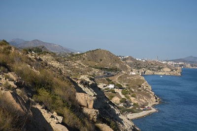 Scenic view of sea and mountains against clear sky