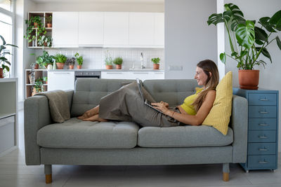 Portrait of woman sitting on sofa at home