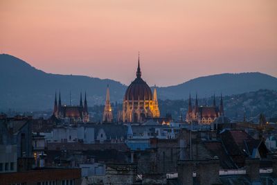 Buildings in city at sunset