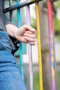 Midsection of woman holding fence