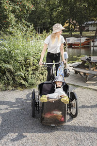 Mother riding bicycle with child in carriage