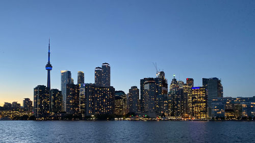 Illuminated buildings in city against sky