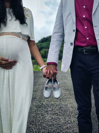 Midsection of couple standing outdoors