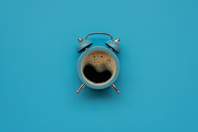 Directly above shot of coffee cup against blue background