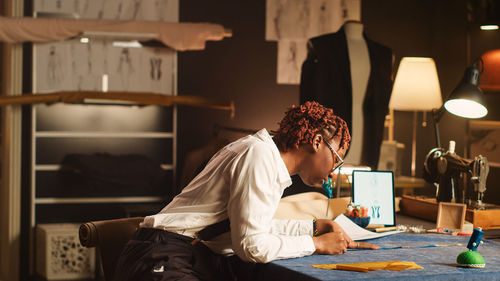 Rear view of woman sitting on table