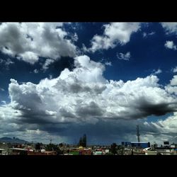 Cityscape against cloudy sky