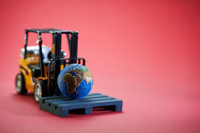 Close-up of toy on table against red background