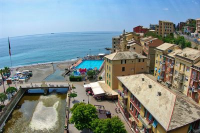 High angle view of townscape by sea against sky