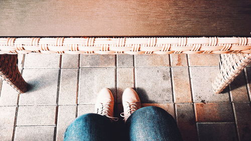 Low section of woman standing on footpath