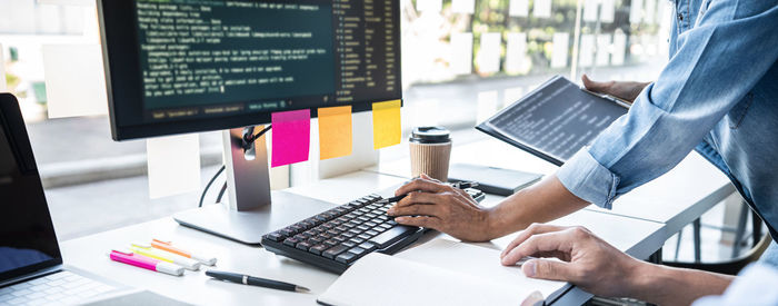 Midsection of man using laptop at office