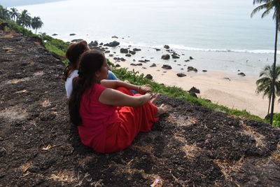 Woman sitting on rock at beach