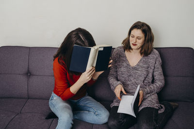 Young woman sitting on sofa at home