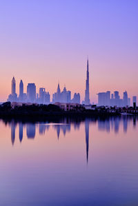 Reflection of buildings in city at sunset