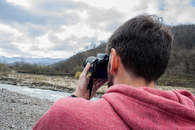 Rear view of woman photographing on mobile phone