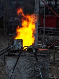 Bonfire on log against orange sky