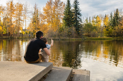 Father and son enjoying view of lake