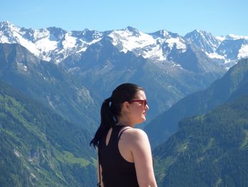 Side view of woman standing against mountains