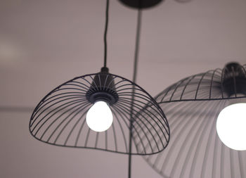 Low angle view of illuminated pendant light hanging from ceiling