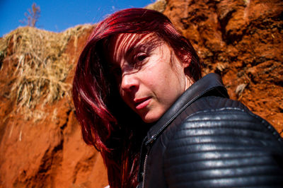 Portrait of beautiful young woman standing on rock