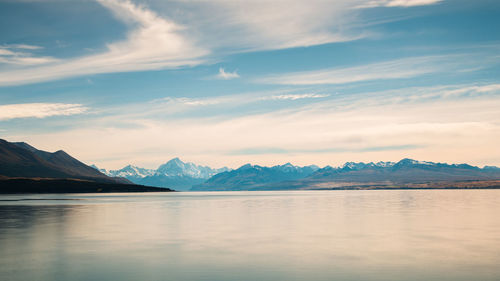 Scenic view of lake by mountains against sky