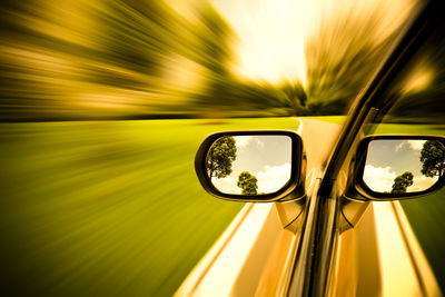 Blurred motion of yellow car on road