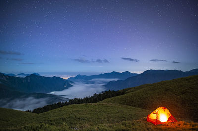 Scenic view of illuminated mountains against sky at night