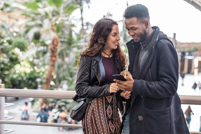 Young couple standing on mobile phone