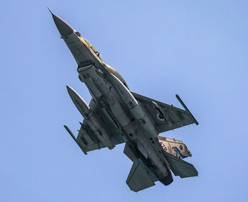 Low angle view of airplane flying against clear blue sky