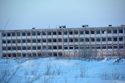 Built structure on snow covered field against clear sky