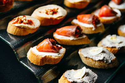 A close up of a glass podium with various bruschettas