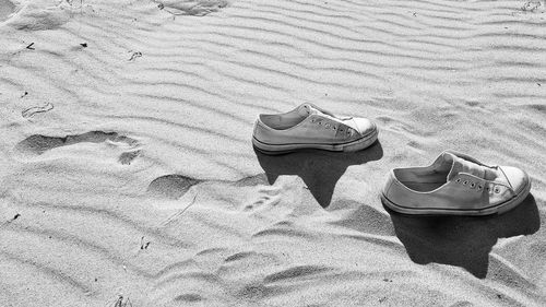 High angle view of shoes on sand at beach