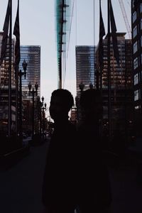 Woman standing by modern buildings in city