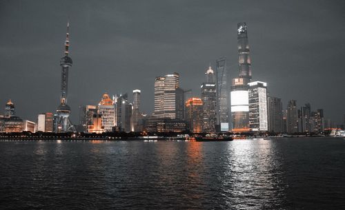 Illuminated buildings in city against sky