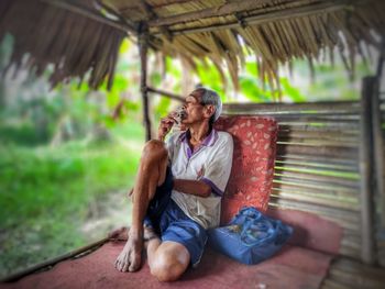 Full length of man sitting outdoors