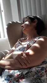 Close-up of mature woman sleeping on sofa at home
